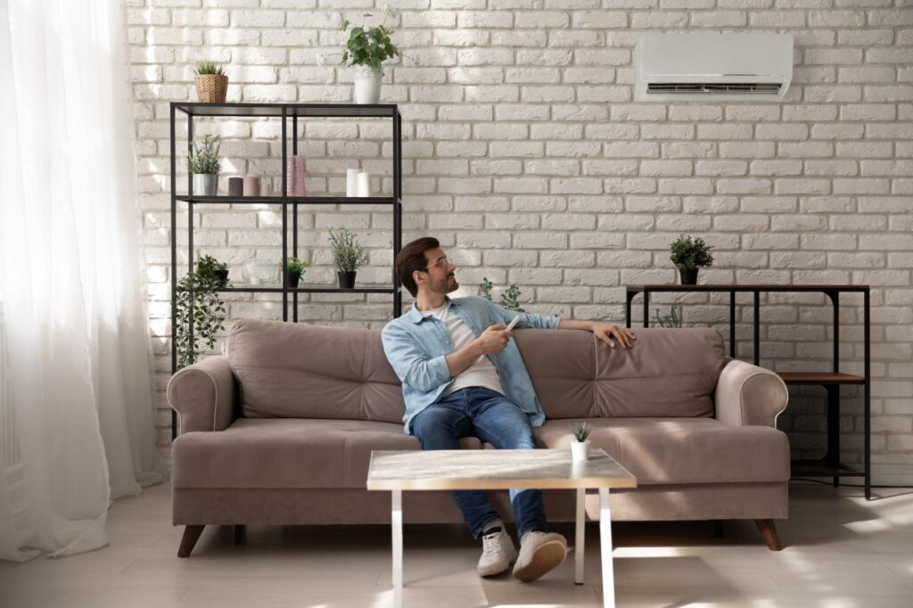 homeowner controlling ductless AC with remote